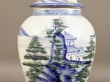 a blue and white vase with a mountain scene on it