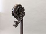 a close up of a metal object with a flower on it