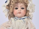 a doll that is wearing a dress and a hat