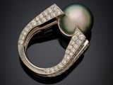 a black pearl and diamond ring on a black surface