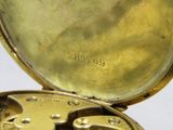 un gros plan d'une montre de poche en or sur fond blanc