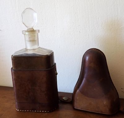 une bouteille et un étui en cuir posés sur une table