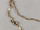a close up of a gold chain on a white surface