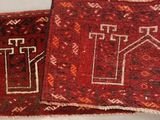two pieces of red and black rugs on a white table