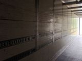 a long hallway leading to a building with a door open