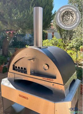 an outdoor pizza oven sitting on top of a table in front of a house