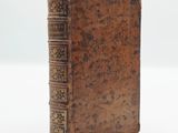 an old book sitting on top of a white surface