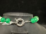 a close up of a necklace with green beads on a mannequin