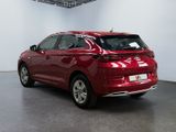 the rear end of a red car parked in a garage