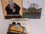 trois livres posés sur une table blanche, avec un chat et une souris