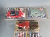 three toy cars are in plastic boxes on a table
