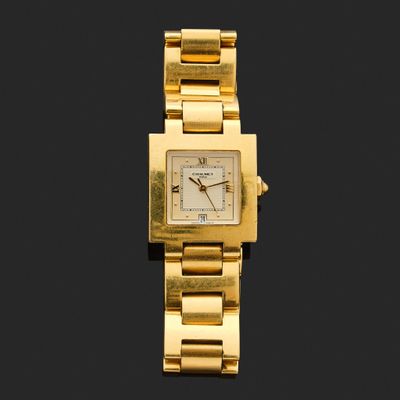 une image montrant un gros plan d'une montre en or sur fond noir