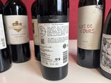several bottles of red wine are lined up on a table
