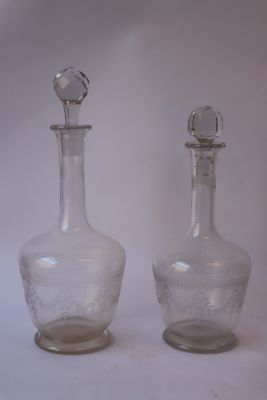 deux bouteilles en verre posées l'une à côté de l'autre sur une surface blanche