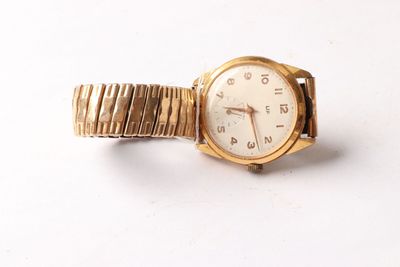 an image of a close up of a wrist watch on a white surface