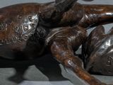 a statue of a dog laying on its back on a table