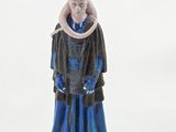 the figurine is made of plastic and has a blue dress