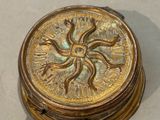 a gold box that has a sun design on it