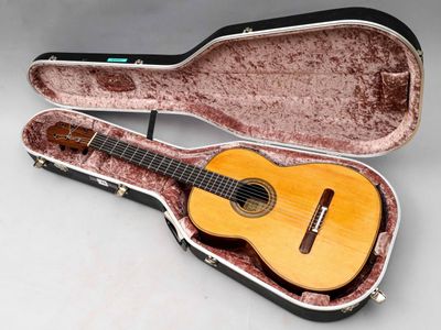 une guitare dans un étui, posée sur une table