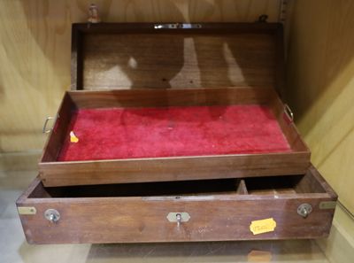 une boîte en bois dont l'intérieur est recouvert d'un tissu rouge