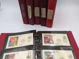 an open red binder sitting on top of a table next to a stack of stamps