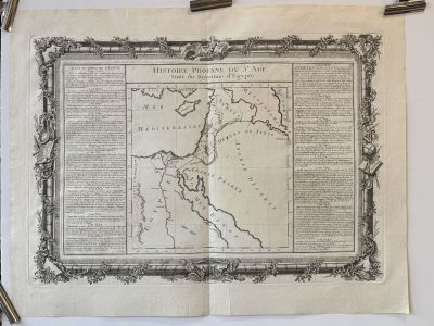 an old map hanging on a wall next to a pair of scissors