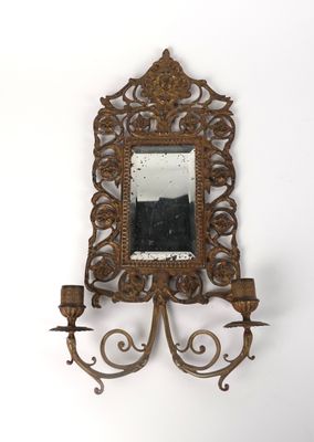 un miroir accroché au mur, sur lequel est posé un bougeoir