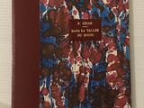 un livre rouge et bleu posé sur une surface blanche