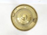 a brass plate with a lid on a white surface
