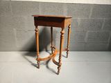 a small wooden table with a drawer on top of it