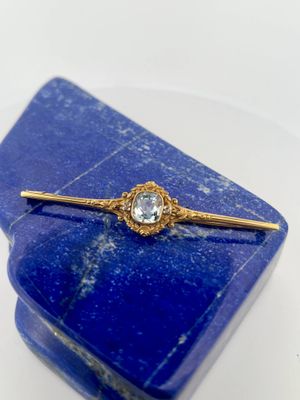 a close up of a blue stone with a gold tie bar