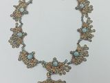 a close up of a necklace on a table with a white background