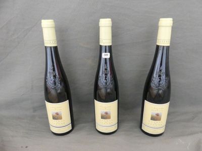 three bottles of wine sitting on a table next to each other