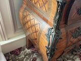 a wooden chest of drawers in the corner of a room