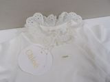 a white shirt with a gold name tag on it