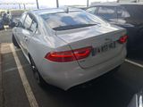 a white car parked in a parking lot next to other cars