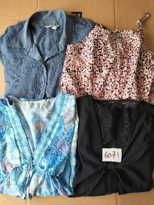 three tops and a bra top sitting on top of a cardboard box