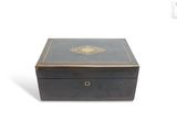 an old black box with a gold medallion on the lid