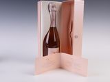 a bottle of wine in a pink box with a spoon in it