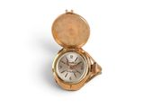 a gold pocket watch sitting on top of a white surface