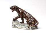 a figurine of a tiger sitting on a rock
