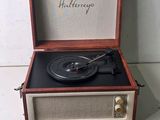 an old fashioned record player with a wooden case and four wooden sticks