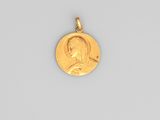 a close up of a gold coin with a man ' s face on it