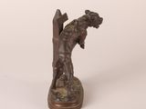an antique bronze statue of a man with a dog on his back