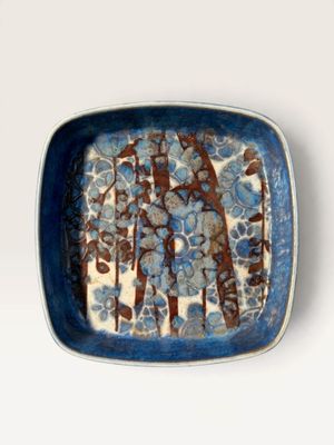 a blue and white plate with a tree design on it