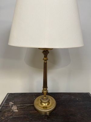 une lampe de table en laiton ancien surmontée d'un abat-jour blanc
