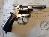 un revolver posé sur une feuille de papier