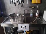 a kitchen with a sink and a lot of utensils hanging on the wall