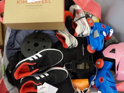 a box full of skates and skateboard gear on the floor