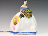 une figurine représentant une femme tenant un bouquet de fleurs